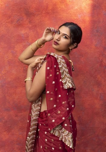 young woman posing while wearing traditional sari garment